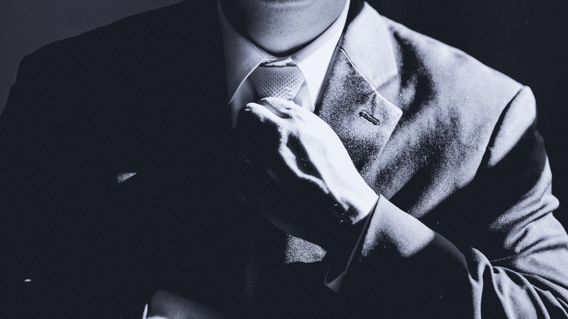 Mann im Anzug rückt seine Krawatte zurecht. Martens & Partner Executive Search